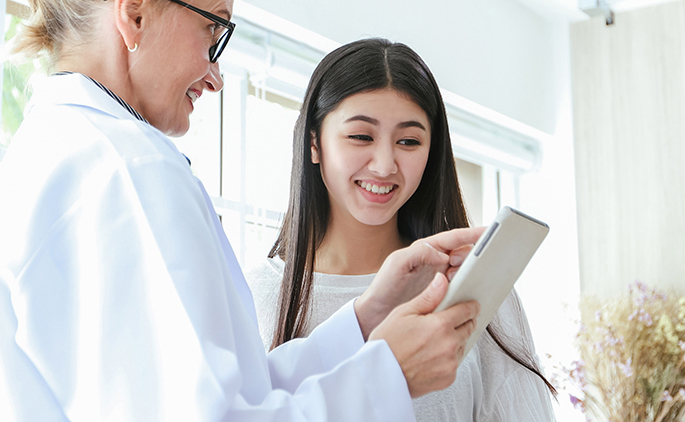 Doctor meeting and explaining medication to woman patient in his office at Hospitals